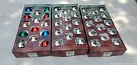 Photo showing three sets of 14 Christmas ornament bulbs each, new in original package. One set with multi-color bulbs and two sets with silver bulbs.