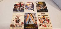 Six 4x8 inch James Bond 007 classic movie poster postcards laid out in 2 rows of 3. Cards show various vintage designs with French text and featuring Roger Moore.