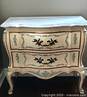 Front view of commode showing marble top, two drawers, painted details and cabriole legs