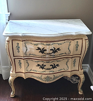 Front view of painted commode showing two serpentine drawers and metal handles
