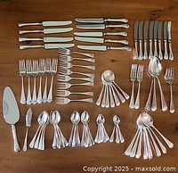 Full set of 79 pieces displayed on a table, showing knives, forks, spoons, and specialty pieces arranged for visual inventory.
