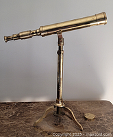 Full side view of brass telescope mounted on tripod