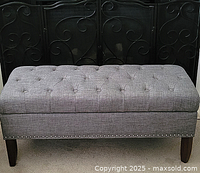 Front view of the button tufted storage bench showing the full length and legs.