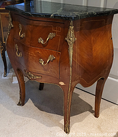 Angled left-side view showing bombé shape, two drawers, marble top and left side profile