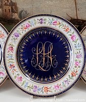 Front view of the Dresden decorative plate showing cobalt blue center with gold monogram and multicolored floral border with gold accents.