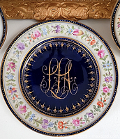 Front view of Dresden plate showing floral border and cobalt blue center with gold monogram.