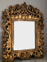 Full view of mirror showing carved frame and reflective glass