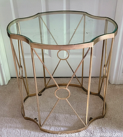 Front view of side table showing scalloped glass top and decorative gold metal frame.