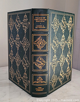 Front and spine view of 'Tales of the South Pacific' leather bound book with gold embossed decoration and gilded edges.