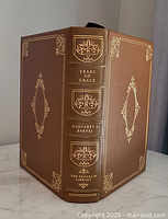 Front view of brown leather bound book titled 'Years of Grace' by Margaret A. Barnes with gold decorations on spine and front cover.