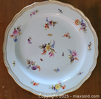 Top view of the Meissen plate showing floral and insect decoration with gold scalloped edge.