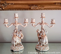 Front view of both porcelain candelabras side by side on reflective surface