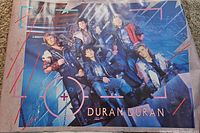 Full view of the colorful 1984 Duran Duran band poster featuring all members posing in leather outfits against an industrial background. The poster measures approximately 34 inches by 23 inches.