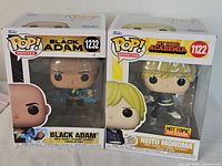 Front view of Black Adam and Neito Monoma Funko Pop boxes, showing new in box condition with clear plastic windows on the packaging.