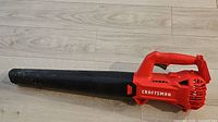 Side view of the Craftsman V20 cordless leaf blower showing the red motor housing and black blower tube.