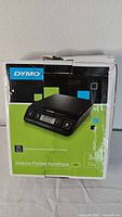 Photo of the Dymo postal scale box showing brand, product image and weight capacity up to 3kg/1.3lb.