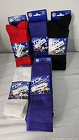 Five pairs of new TCK All Sport knee-high athletic socks in various colors arranged on white surface.