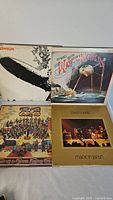 Four vinyl record albums displayed with covers visible: Led Zeppelin, Jeff Wayne's War of the Worlds, Deep Purple Made in Japan, Strawbs Grave New World.