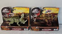 Two Jurassic World Dino Escape boxed dinosaurs: Styracosaurus and Masiakasaurus, shown side by side.