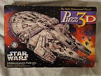 Box of Star Wars Millennium Falcon 3D puzzle showing the artwork of the finished model and branding.