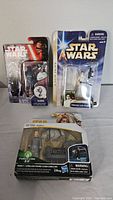 Three Star Wars toys in original packaging arranged for photo: Kylo Ren and Princess Leia Organa figures on top, Rebolt Corellian Hound Ichien Corellien figure with accessories boxed below.