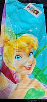 Photo showing close-up of the Tinkerbell face design on the towel, with part of the turquoise background visible.
