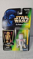 Front view of vintage Star Wars R5-D4 action figure in original packaging featuring Darth Vader artwork and accessory visible in blister pack.