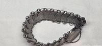 Full view of bracelet showing linked Dutch 10-cent coins and clasp