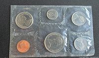 Obverse view of six coins in sealed plastic