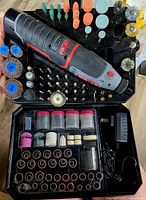 Rotary tool with accessory trays showing sanding drums, grinding stones, polishing wheels and other bits