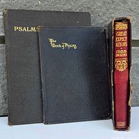 Front view of three books upright showing titles and sizes