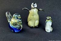 Front view of all three glass penguin figurines