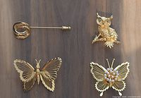 Front view of all four Monet gold-tone brooches