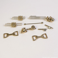 Group shot of all eleven tie bars, stick pin and lapel pins