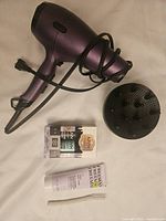 Photo showing purple Conair hairdryer with diffuser attachment, Nyx finishing spray 2-pack, Freeman Relax jelly mask tube, and Wild Pier dermaplaner in packaging.