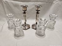Photo of all three pairs of candlesticks, two pairs of clear crystal swans and one pair of metal filigree candlesticks.
