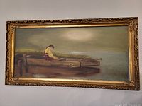 Framed oil painting of a girl in a wooden boat near a dock, with tall grass in background. Earth tone palette, muted colors, signed by artist.