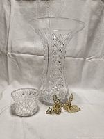 Photo showing the large clear cut crystal vase alongside the small condiment bowl and butterfly clips, highlighting the detailed cut patterns and golden butterfly accessories.