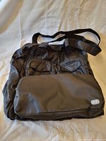 Black LUG Puddle Jumper tote bag front view showing three zipper pockets and LUG logo patch.