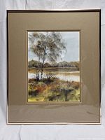 Framed watercolour landscape painting showing the full artwork behind glass within a beige mat and simple wood frame.