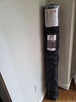 Photo of the rolled-up YO GORILLA exercise mat in black carrying bag.