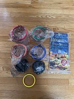 All accessories laid out: four mugs with lip rings, five rings total, black lids, recipe booklet