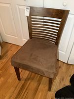 Front view of the modern wooden chair with padded seat showing the slatted back design and brown microfiber cushion.