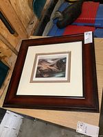 The framed artwork placed with visible frame and corner details.