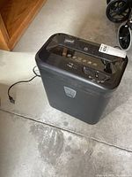 Full view of the Staples paper shredder showing overall shape, power cord, and pull-out bin area.