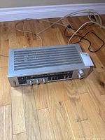 Top angle view of vintage Pioneer receiver SX-202 showing ventilation slots and cords attached.