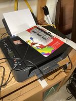 Photo showing Canon Pixma TS3420 printer with documents in output tray and power cord attached.