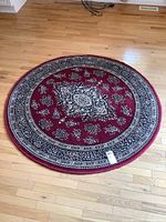 Round area rug laid on hardwood floor showing full rug and pattern.