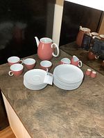 Full tea set displayed on a countertop including teapot, cups, saucers, plates, creamer, sugar, salt and pepper shakers.