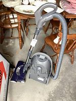 Side view of Kenmore canister vacuum with hose and wand attached, showing overall shape and attachments.